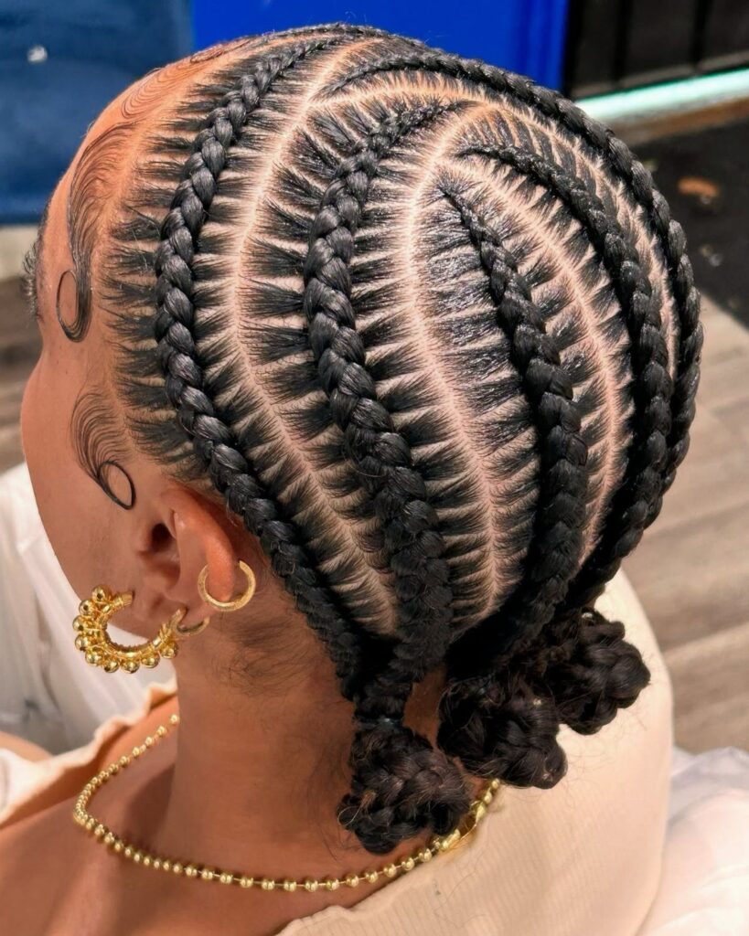 Curved cornrows gather into small braided buns at the nape