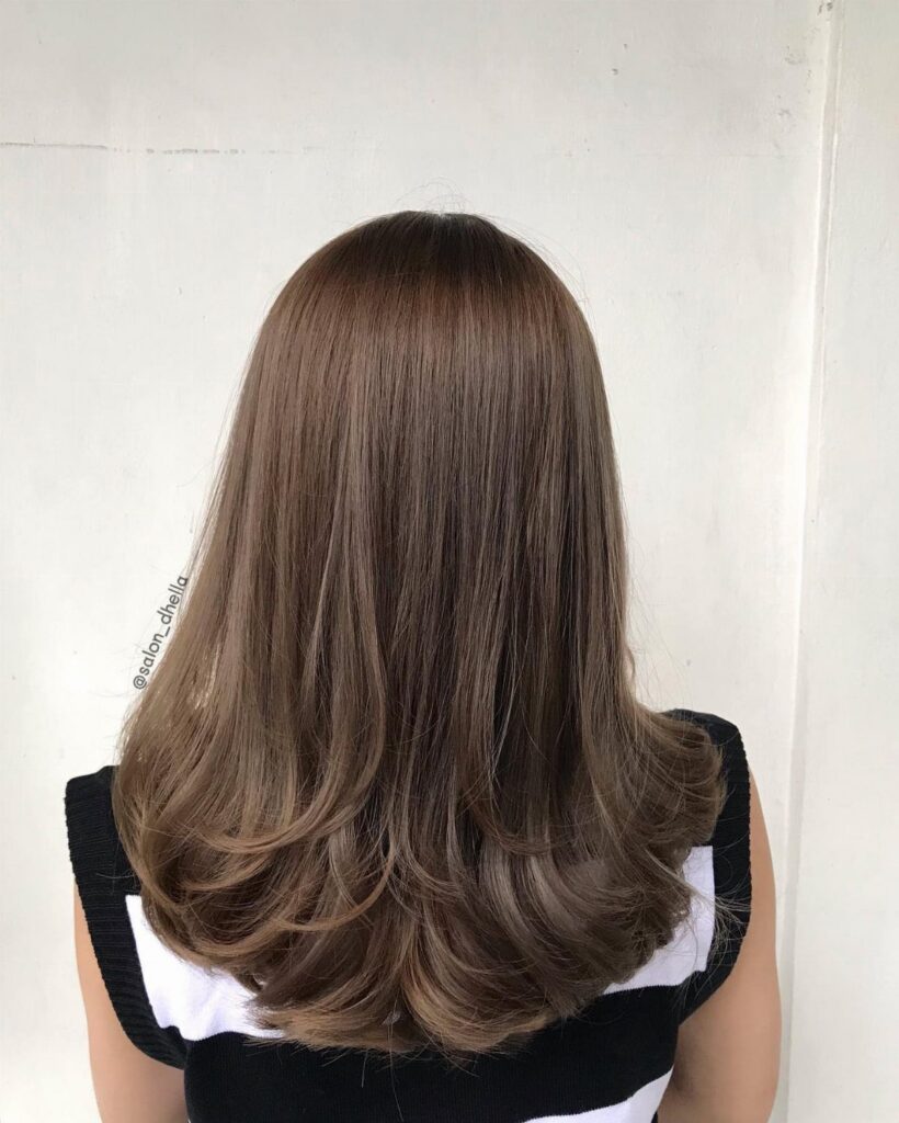 Layered medium-length brown haircut with softly curled ends viewed from behind