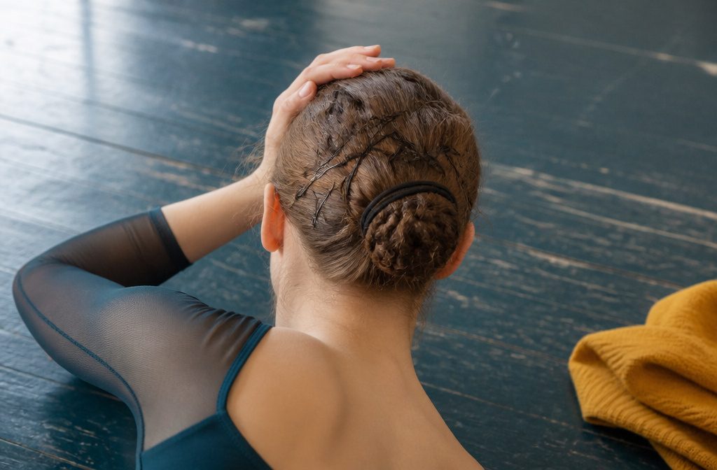 Dancer with hair pinned up during rehearsal, face clear