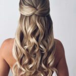 Half-up twisted hairstyle with long cascading blonde curls viewed from behind