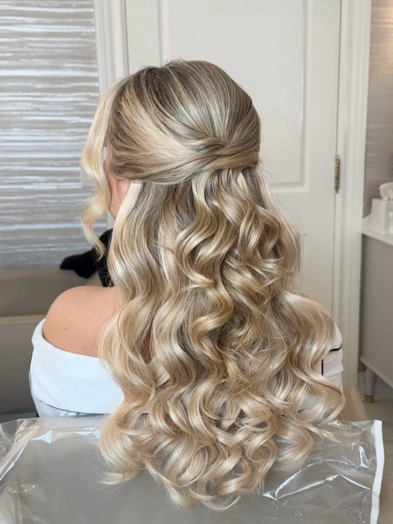 Blonde half up half down hairstyle with cascading curls viewed from behind