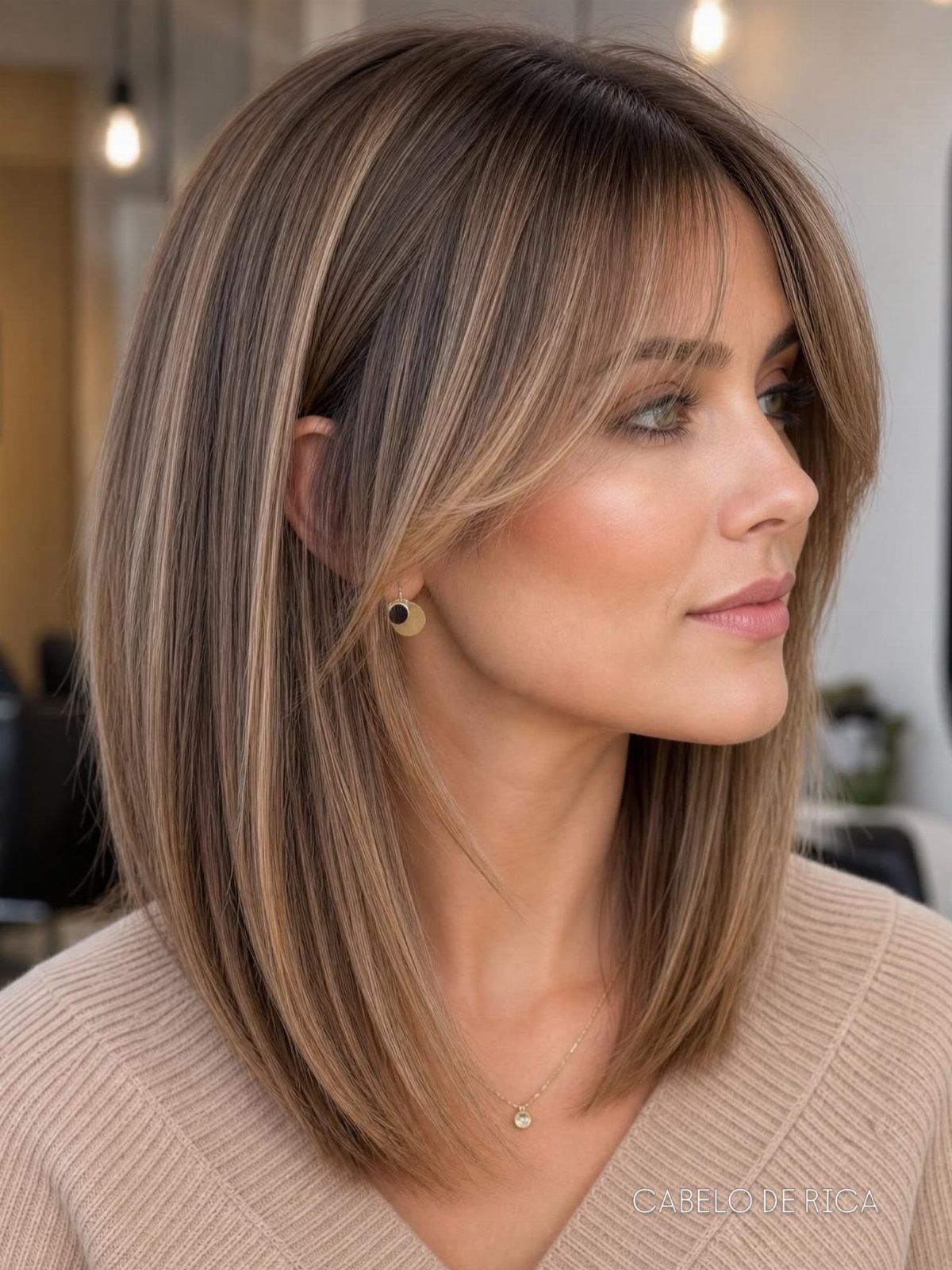 Woman showing a shoulder-length layered haircut with highlighted face-framing bangs