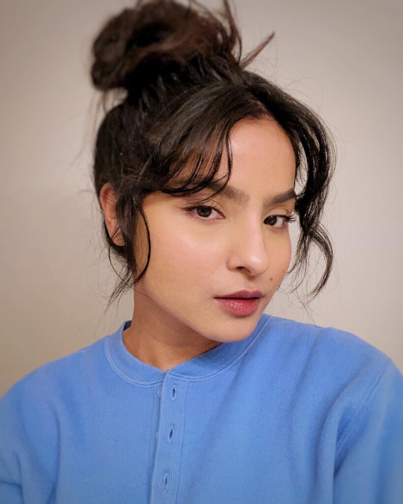 Woman wearing a loose messy bun hairstyle with wispy face-framing strands