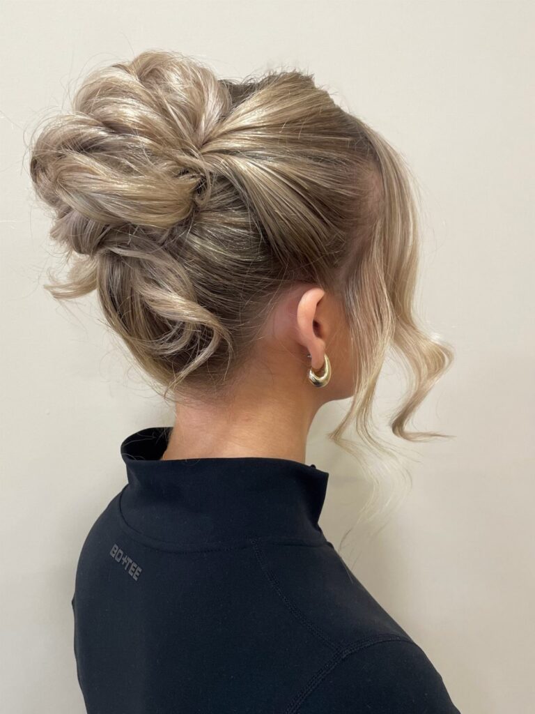 Blonde short hair styled into a voluminous updo with loose curls